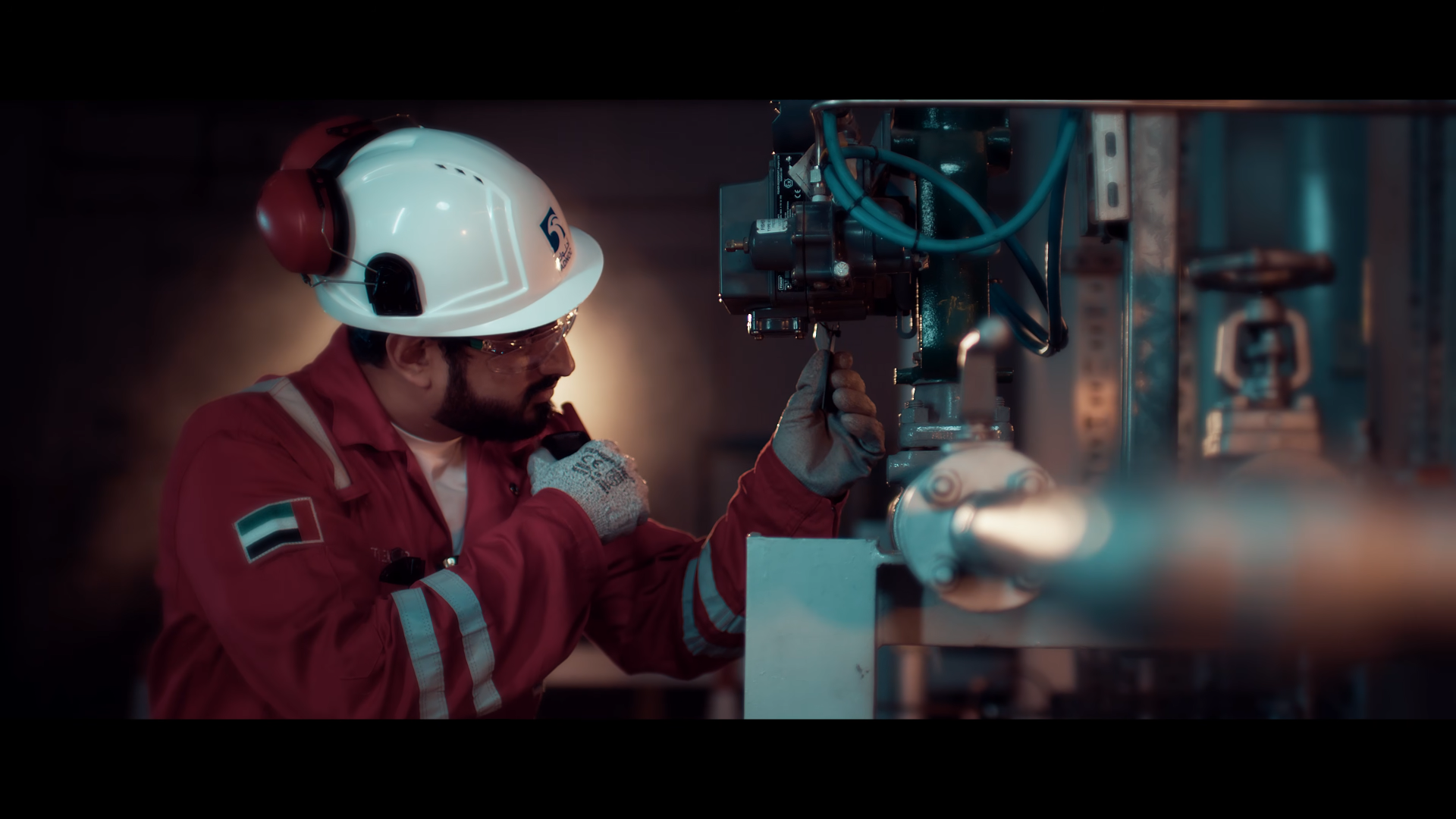 Worker in red overalls operating industrial machinery